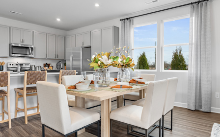A kitchen with a dining table and chairs.