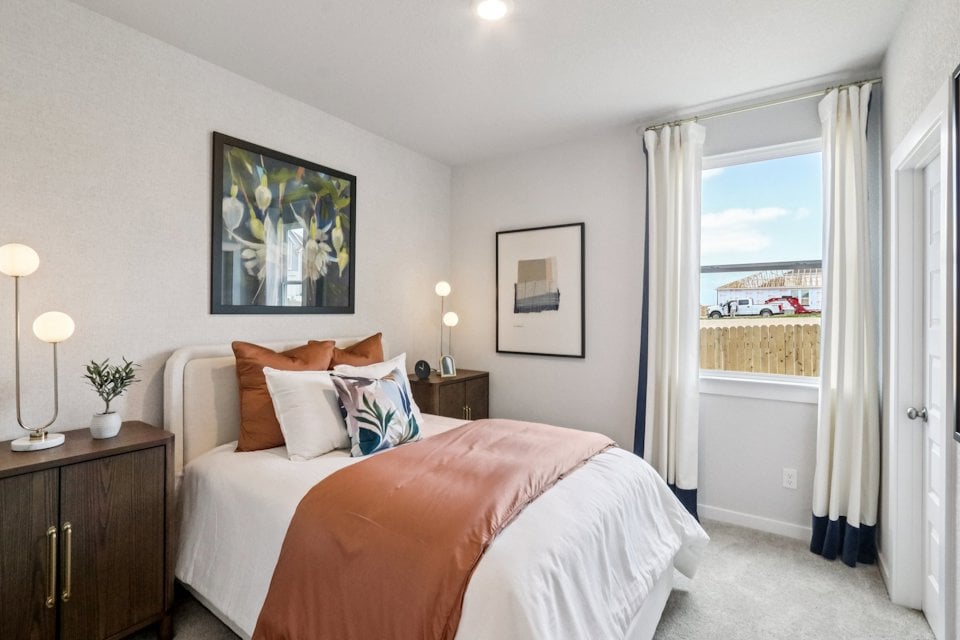 A bedroom with a large window.