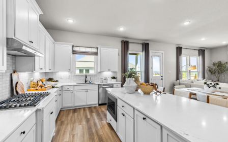 A kitchen with white cabinets.