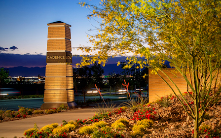 A stone monument with a sign on it by a body of water.