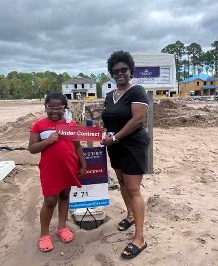 A woman holding a sign next to a man holding a sign.