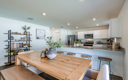 A kitchen with a table and chairs.