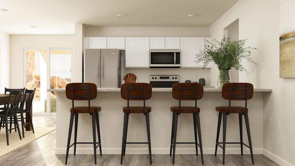 A kitchen with a table and chairs.