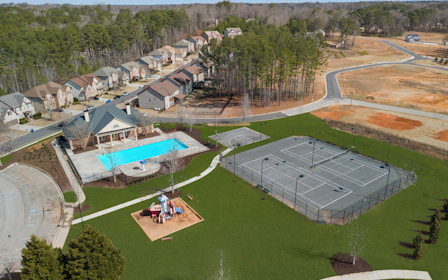 A group of houses and a large green field.