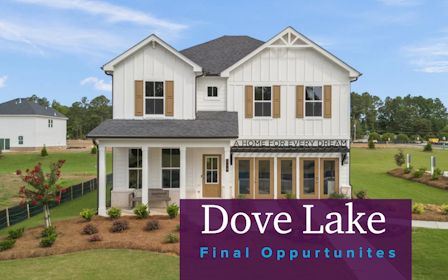 A white house with a sign in front of it.